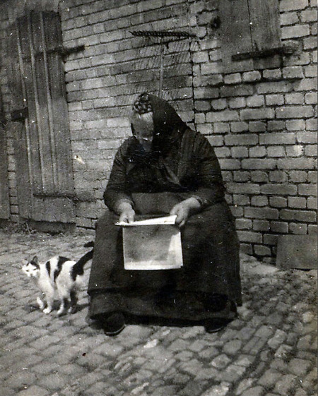 Ältere Frau aus Rollshausen auf ihrem Hof sitzend, um 1930