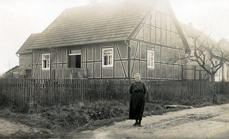 Ältere Frau vor einem Haus in Wetterburg, um 1930