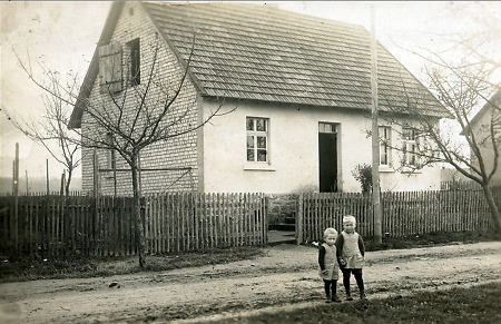 Zwei Kinder vor einem kleinbäuerlichen Haus in Wetterburg, um 1920