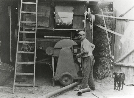 Mann in Kerspenhausen vor einer Dreschmaschine, um 1960