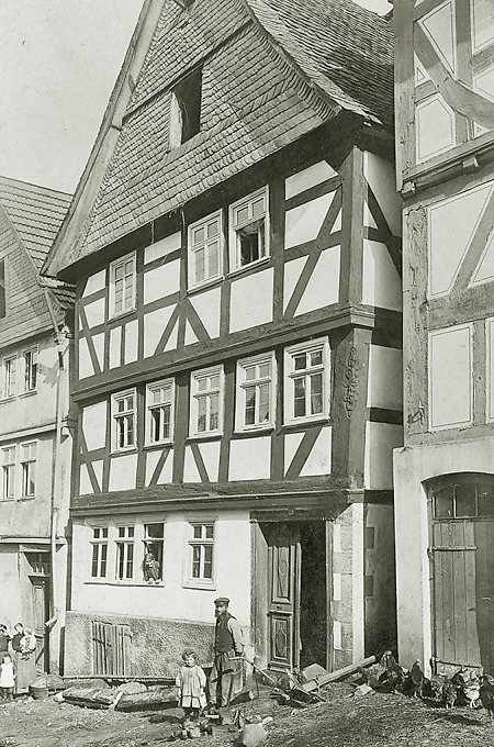 Personen vor einem Fachwerkhaus in der Schmiedegasse in Frankenberg, 1910
