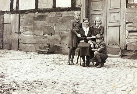 Mutter mit ihren drei Kindern in Haubern, um 1940