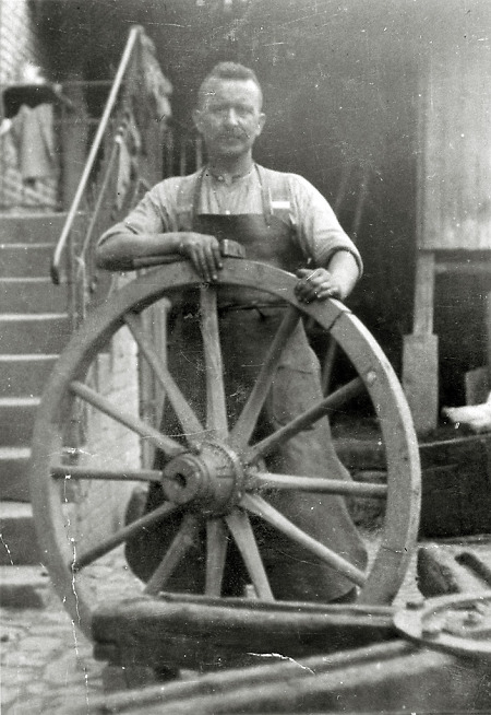 Schmied in Leidenhofen beim Aufziehen eines Reifens auf ein Wagenrad, 1930er Jahre
