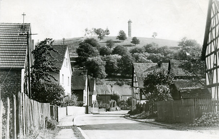 Dorfstraße in Merkenbach mit dem Wasserturm, um 1960