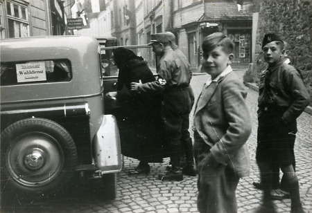 Der Wahldienst, gestellt von der NSDAP, bringt eine Frau nach der Wahl im Auto nach Hause, 1933