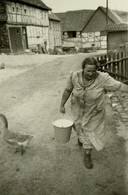 Frau aus Walburg mit Milcheimer auf der Dorfstraße, Anfang 1950er Jahre