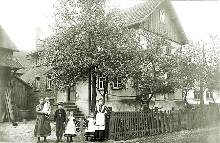 Zwei Frauen mit Kindern vor einem Haus in Saasen, 1912