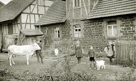 Familie mit ihren Haustieren hinter ihrem Haus in Hauptschwenda, 1947
