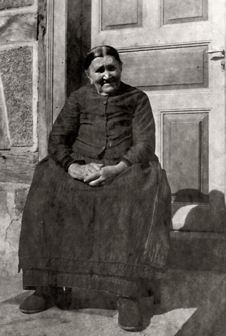 Alte Frau aus Queckborn vor ihrem Haus, um 1920?