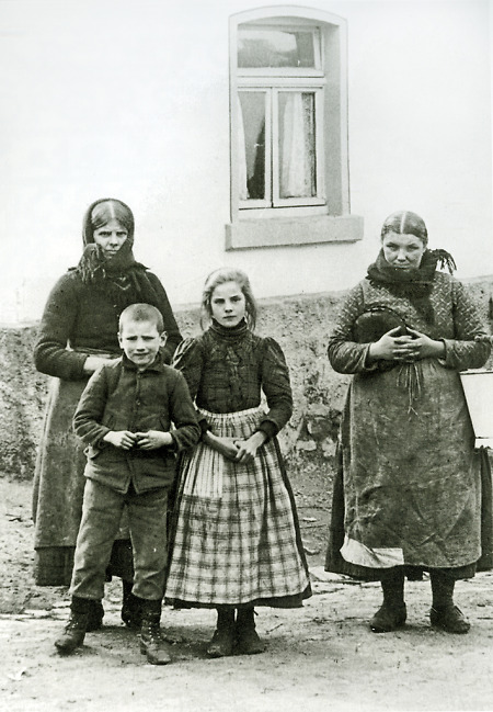 Frau mit zwei Kindern und Schwägerin vor dem Haus in Daubringen, 1910
