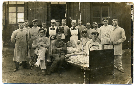 Verwundete, Pfleger und Krankenschwestern vor einer Lazarettbaracke, 1914-1918