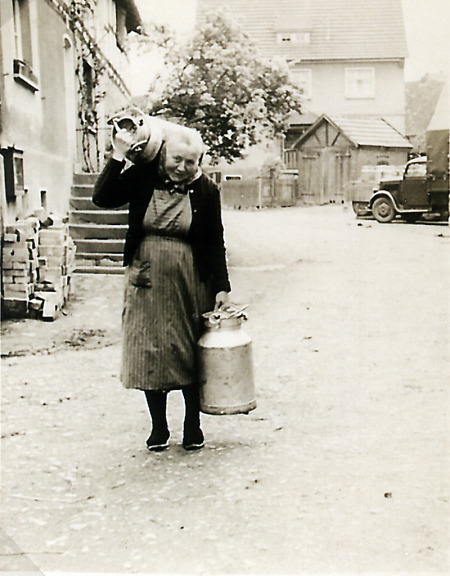 Ältere Frau in Hattenbach auf dem Heimweg mit leeren Milchkannen, undatiert