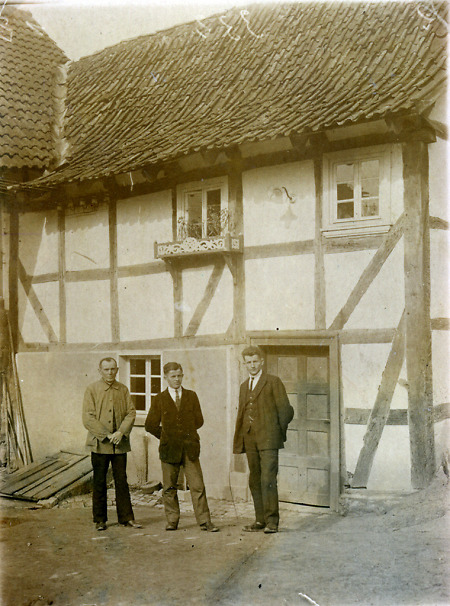 Mann mit zwei Söhnen vor dem Haus in Hattenbach, um 1925