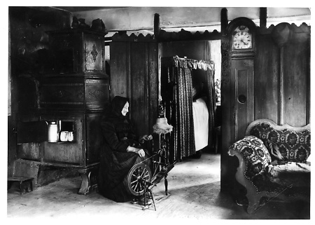 Einblick in eine Schwälmer Wohnstube, in der eine Frau am Spinnrad sitzt, 1920er Jahre?