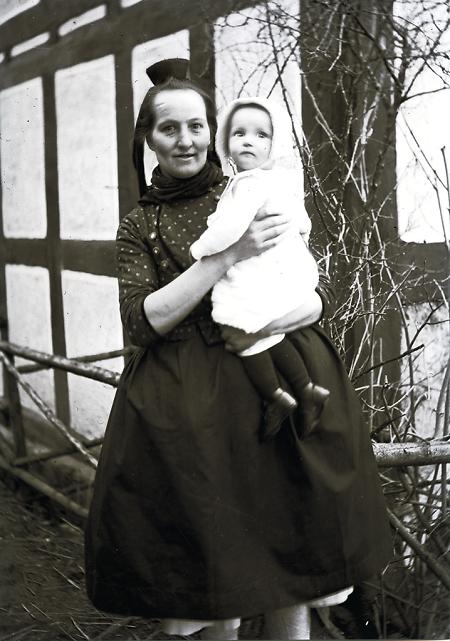 Schwälmerin mit Kleinkind im Pfarrgarten Holzburg, um 1935