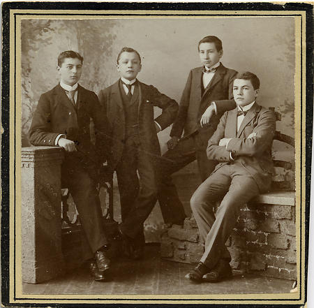 Vier Jugendliche in feiner Kleidung im Atelier, um 1900