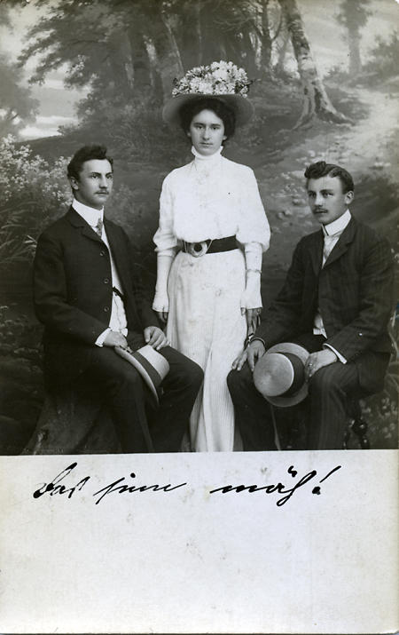 Junges Mädchen inmitten zweier junger Herren im Atelier, um 1900