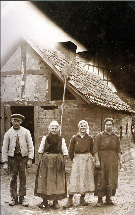 Vier Einwohner vor dem Backhaus in Haubern, um 1930