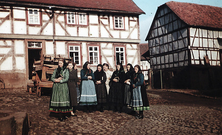 Junge Frauen in Stausebach beim Kirchgang vor der Schule, späte 1950er Jahre