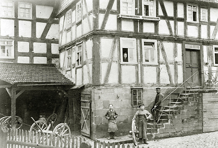 Schmiedemeister mit Gesellen vor seinem Haus in Hachborn, um 1920