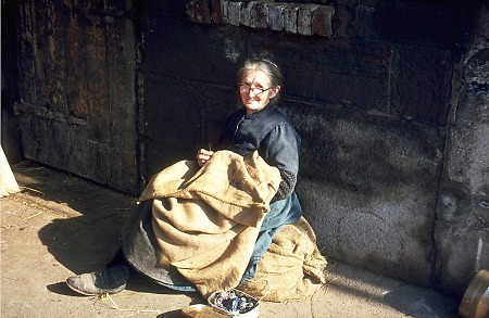 Ältere Frau aus Röddenau beim Flicken von Kartoffelsäcken, um 1966