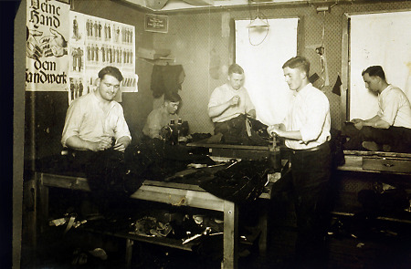Schneidermeister mit vier Gesellen in seiner Werkstatt, um 1930