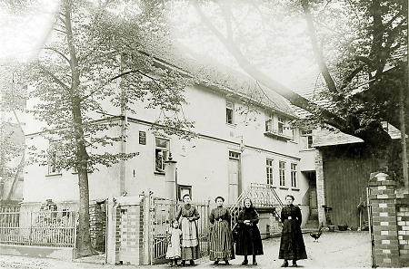 Frauen mit einem Mädchen vor einem Haus in der Gießener Straße in Saasen, 1914