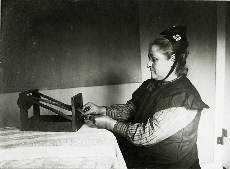 Frau aus Nieder-Modau beim Herstellen von Schürzenbändern, 1910