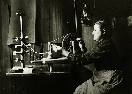 Frau an einem Handspinnrad in Brandau, 1910