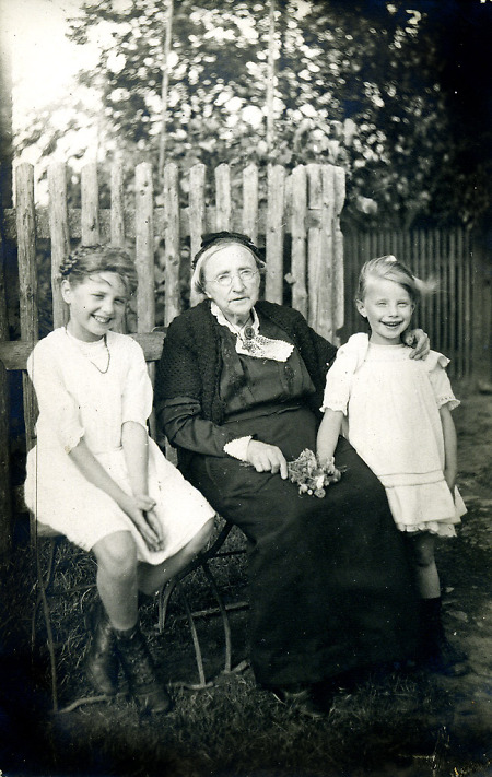 Alte Frau in Marburg mit zwei Mädchen, um 1922