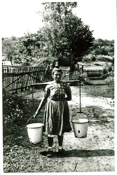 Junge Frau beim Transport von Eimern mit einem Joch, 1938-1945