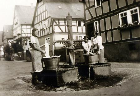 Drei Frauen am Oberdorf-Brunnen in Nanzenbach, um 1940
